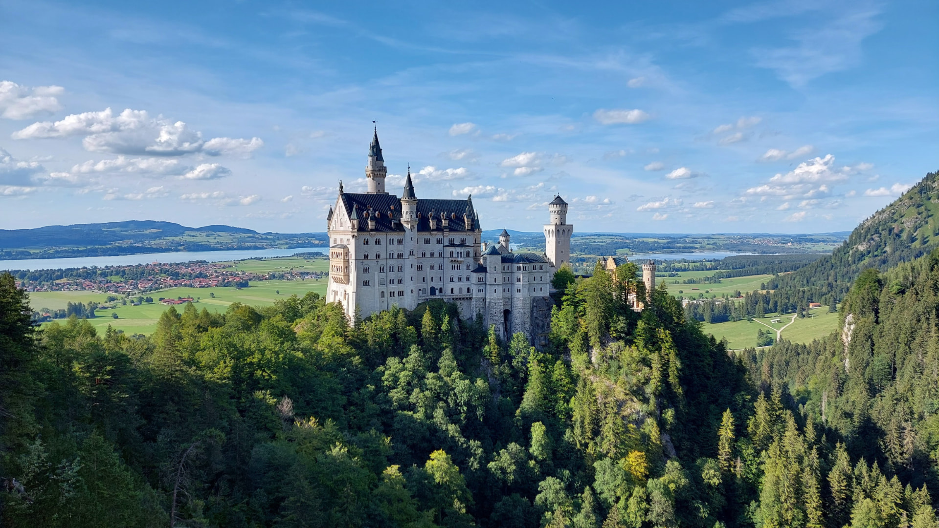 Neuschwanstein Castle seen from Marienbrücke, with the Bavarian Alps behind it.