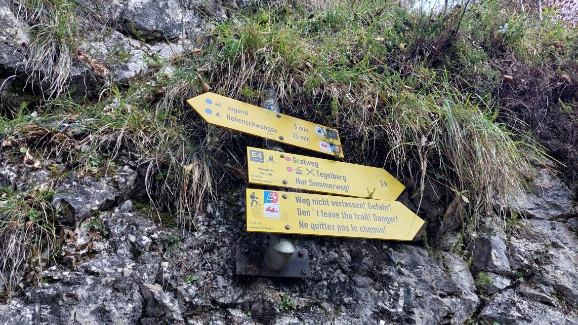 hiking-sign-marien-bridge-neuschwanstein-castle-bavaria-germany hiking sign with directions and times at marien bridge neuschwanstein castle, bavaria-germany