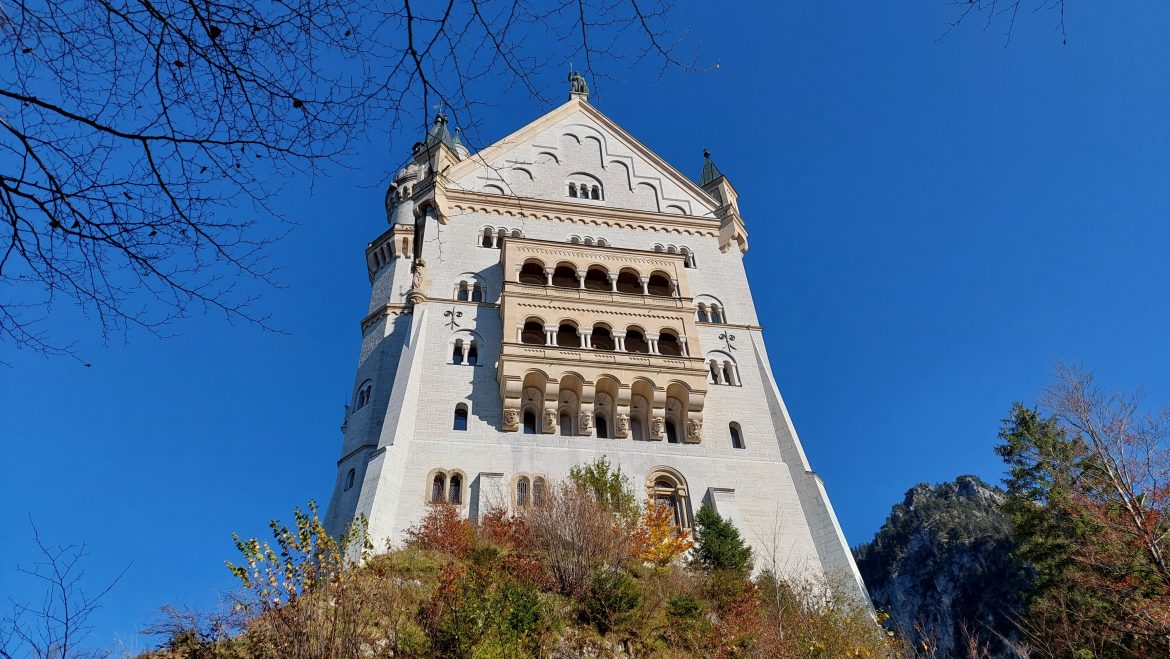 neuschwanstein-castle-back-autumn-bavaria-germany back view of neuschwanstein castle in autumn with colorful foliage, bavaria-germany