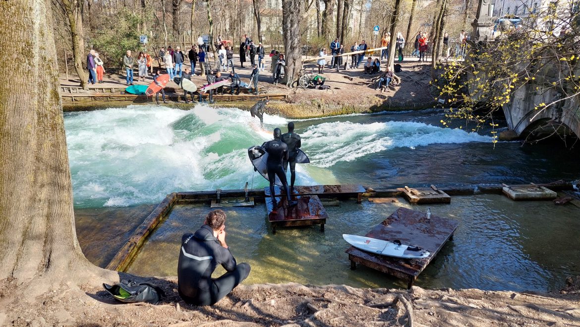 surfing-eisbach-english-garden-munich-bavaria-germany people surfing eisbach wave english garden munich bavaria germany early spring bavaria germany