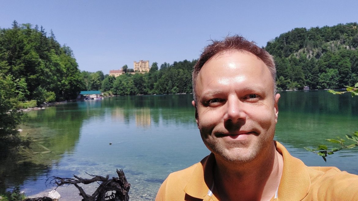 Martin Hakel by Alpsee with Hohenschwangau Castle, sunny day, Bavaria, Germany